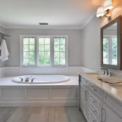 Updated bathroom with tub and dual-sink vanity by a Miami handyman. Miami handyman bathroom remodel with soaking tub, double vanity, and mirrors