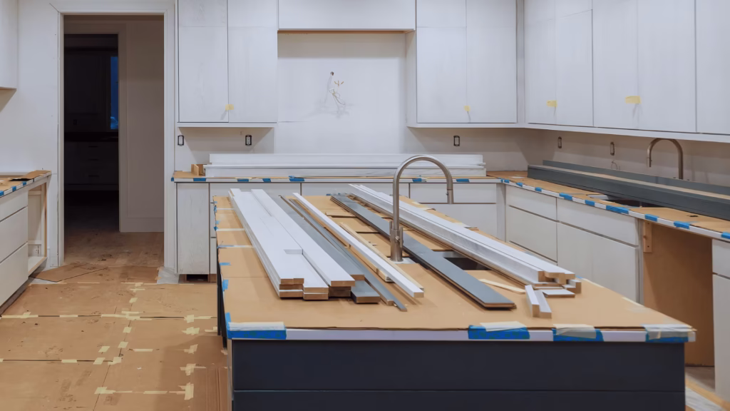 Kitchen remodel in Miami new white cabinets island sink trim boards staged for install