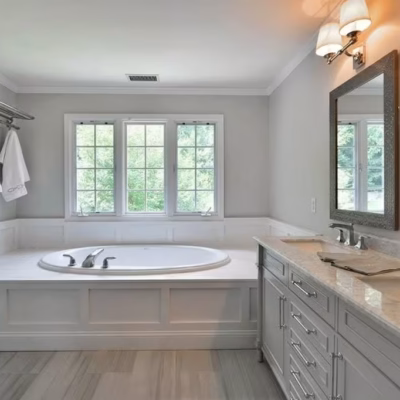 Updated bathroom with tub and dual-sink vanity by a Miami handyman. Miami handyman bathroom remodel with soaking tub, double vanity, and mirrors